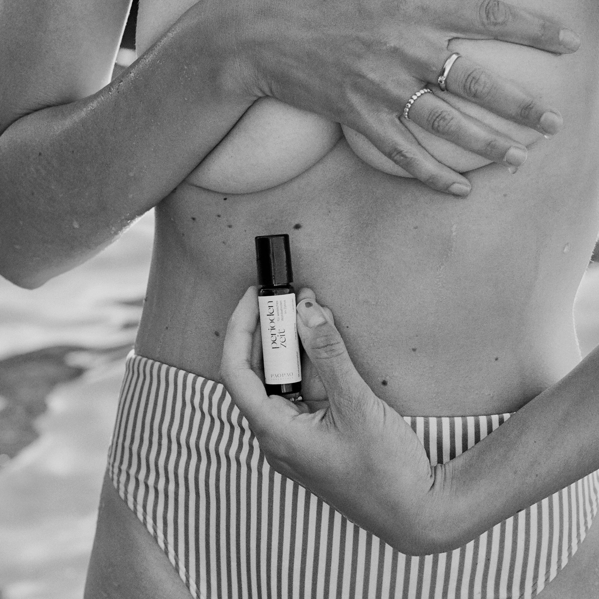 Anwendung des PMS Roll-Ons auf dem Bauch zur natürlichen Schmerzmittel-Linderung.