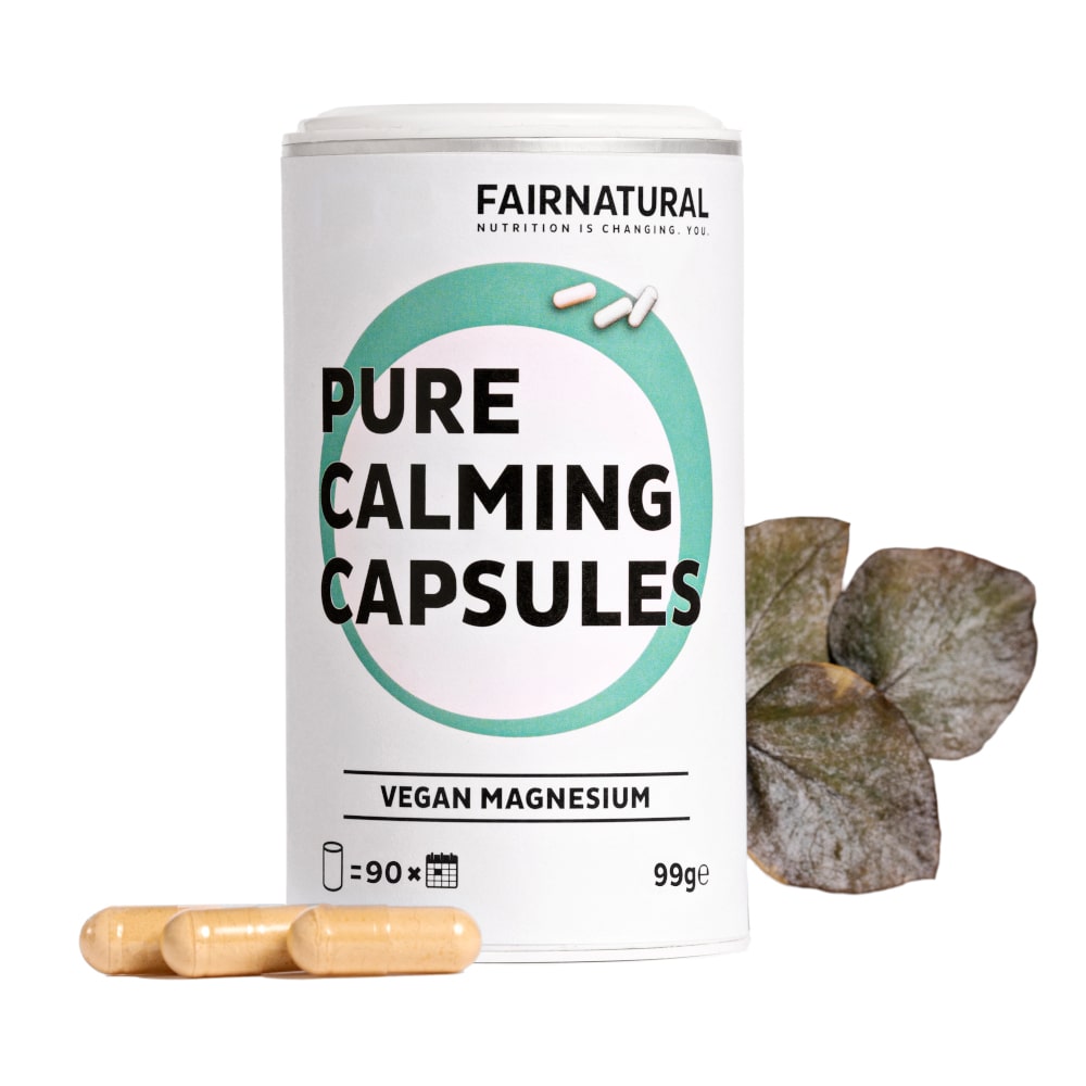 Hauptproduktbild der Fairnatural® Magnesium Kapseln in einer transparenten Verpackung, umgeben von grünen Pflanzen.