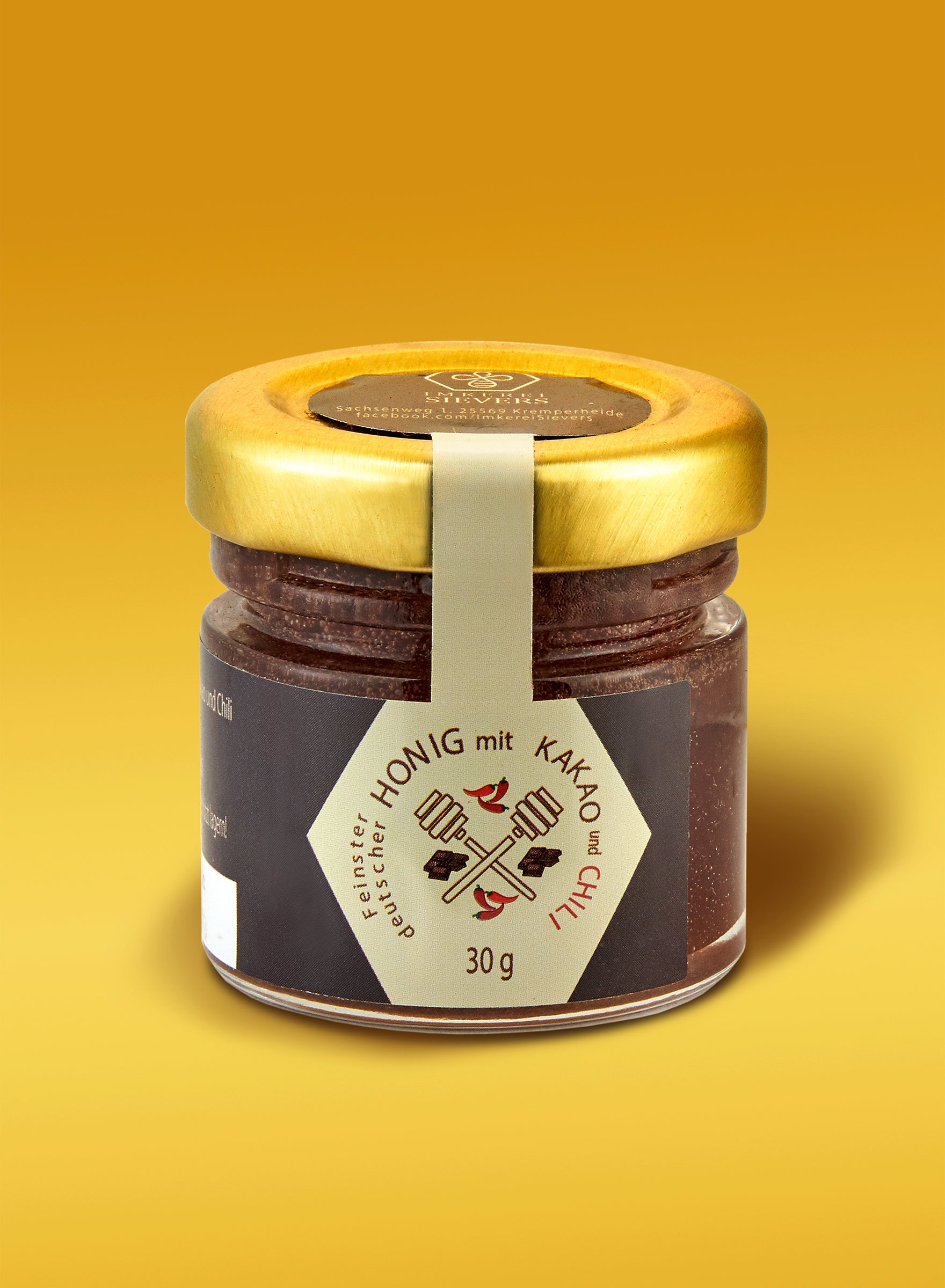 Premium Honig mit Kakao und Chili von Nordbienchen in einem Glas mit goldener Farbe