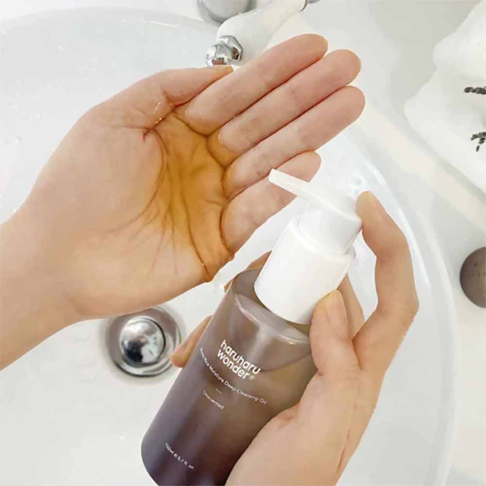 Anwendung des Black Rice Cleansing Oils auf der Hand, zeigt sanfte Textur und leichte Emulsion für die Gesichtsreinigung.