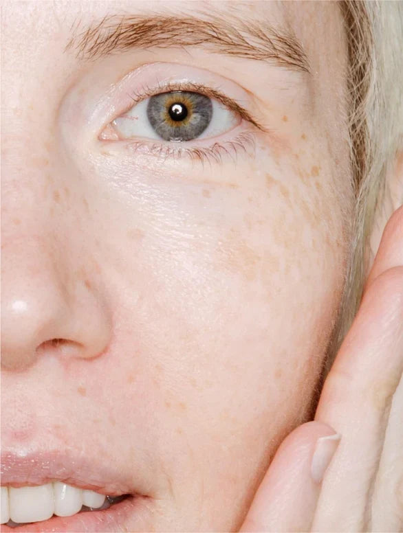 Frau sprüht Microbiome Face Mist auf ihr Gesicht, optimal für feuchtigkeitsspendende Pflege.