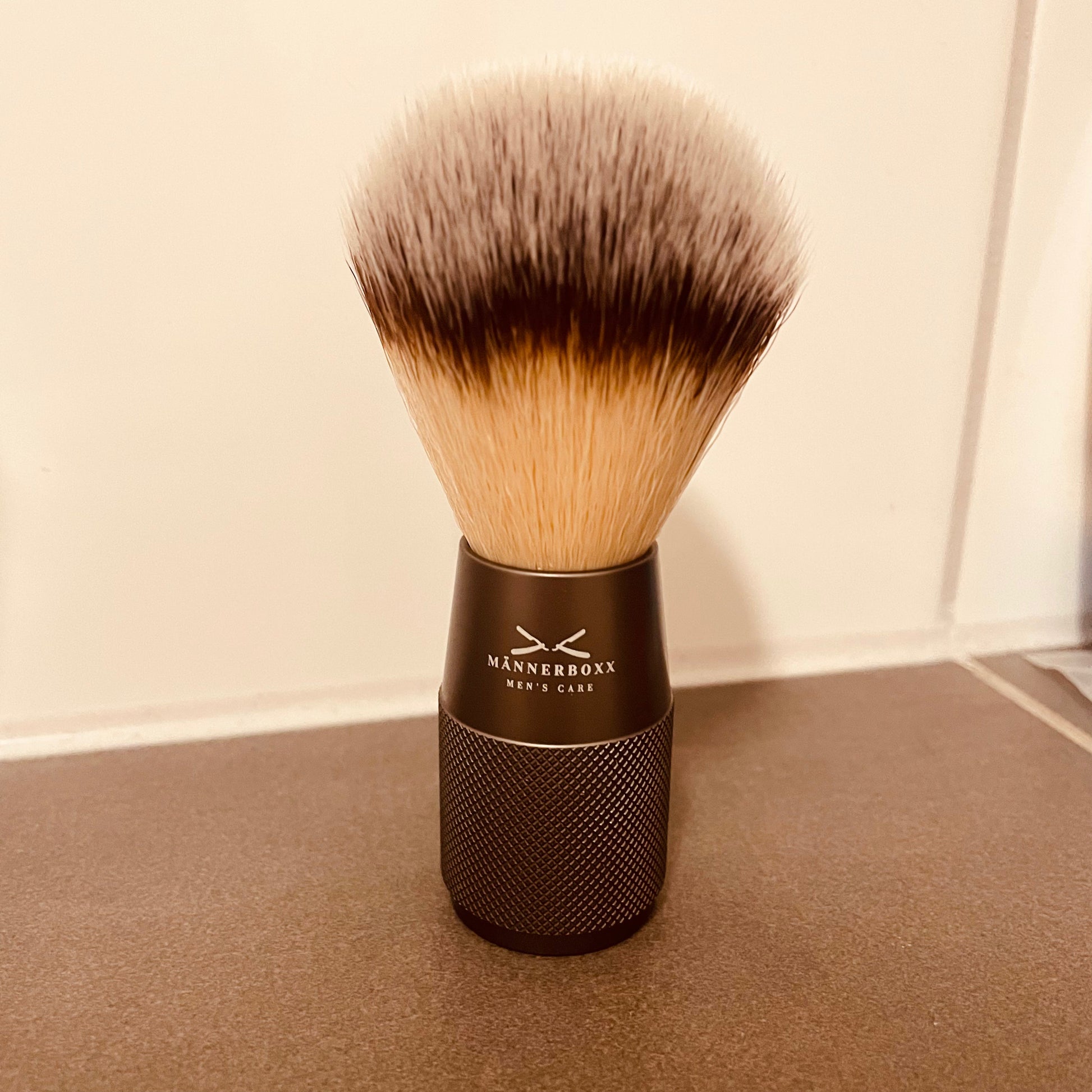 Verpackung des veganen Rasierpinsels von Männerboxx mit Informationen zu Anwendung und Pflegehinweise.