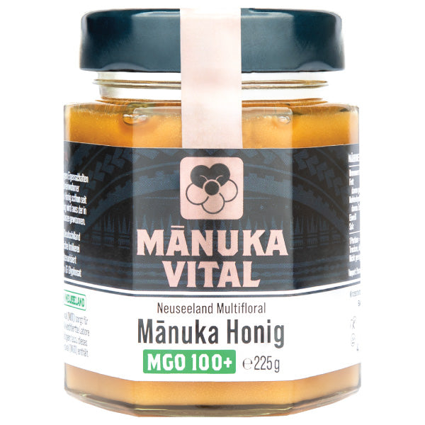 Manuka Honig MGO 100+ von ekovita in einem eleganten Glasbehälter, 225g, auf einem Holzuntergrund.