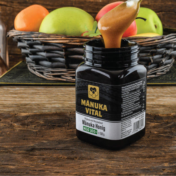 ManukaWelt Manuka Honig MGO 300+ als gesunde Zutat in einer Teetasse, harmonisch mit frischen Kräutern.