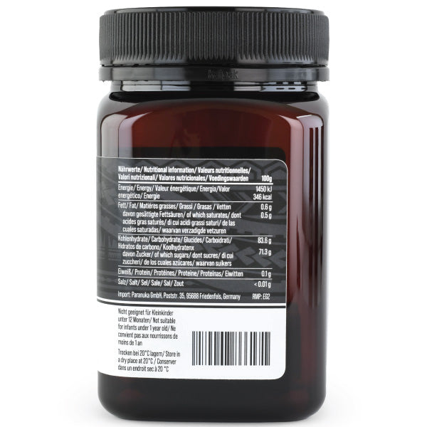 Manuka Honig von ekovita in einer offenen Glasverpackung, umgeben von Natur, um die Reinheit zu betonen.