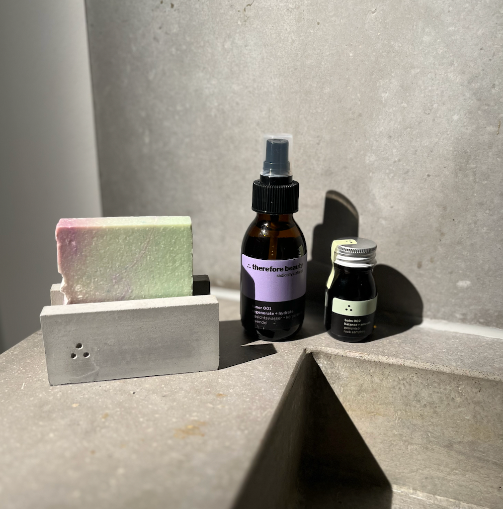 Verpackung des Toners 001 von therefore beauty, umgeben von frischen Lavendelblüten.